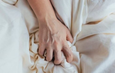 Una imagen de una mano agarrando sábanas.